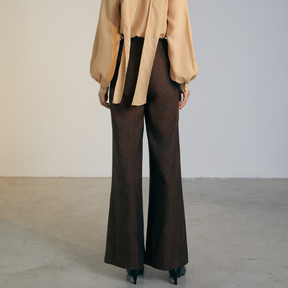 The back of a model wearing brown colored loose Pants