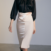 Close-up of the front of a model wearing an ivory colored Twisted Skirt
