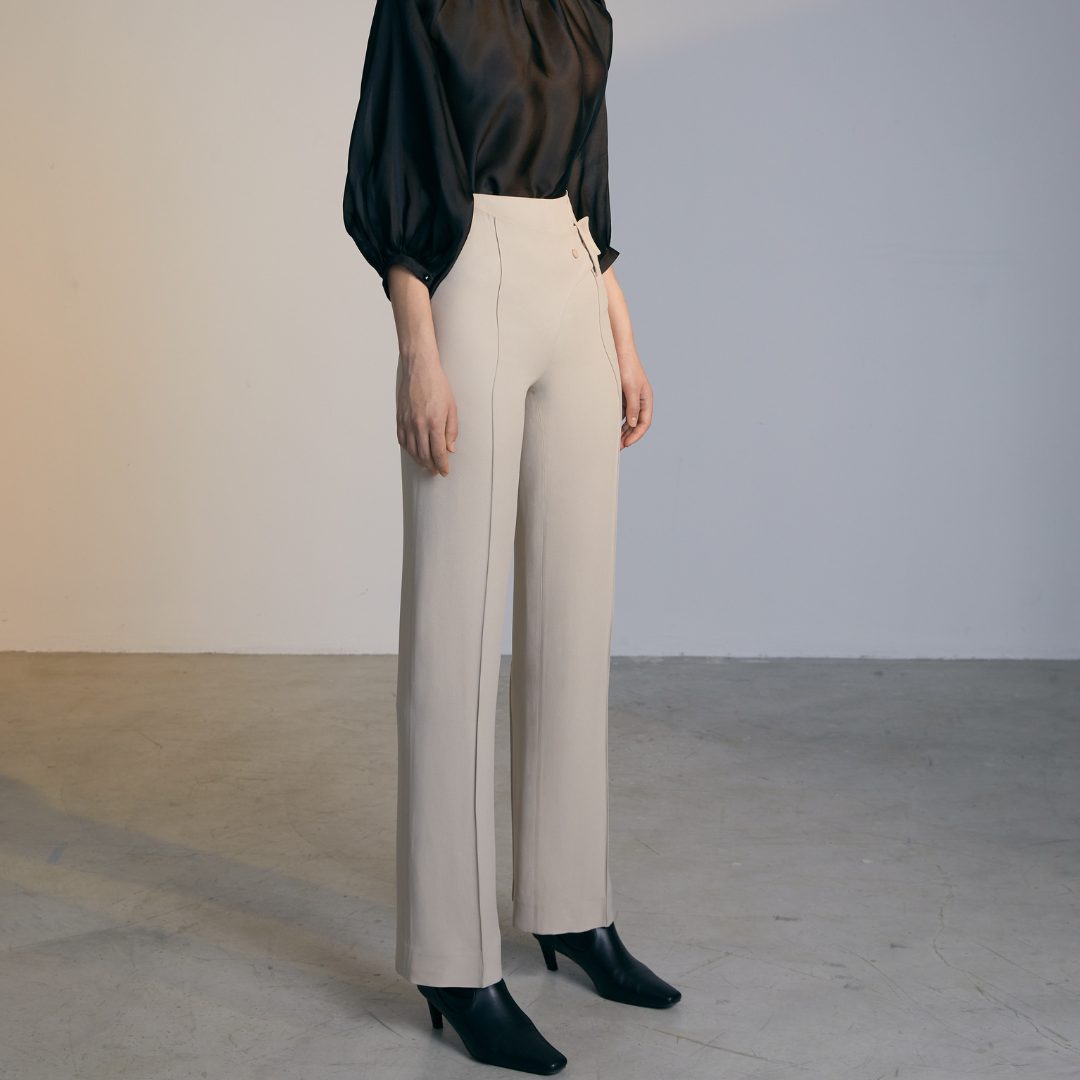 The side of A model wearing Natural colored Asymmetrical Belt Pants
