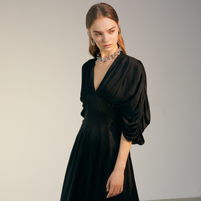 The side of a model wearing a black Bat Sleeve Dress