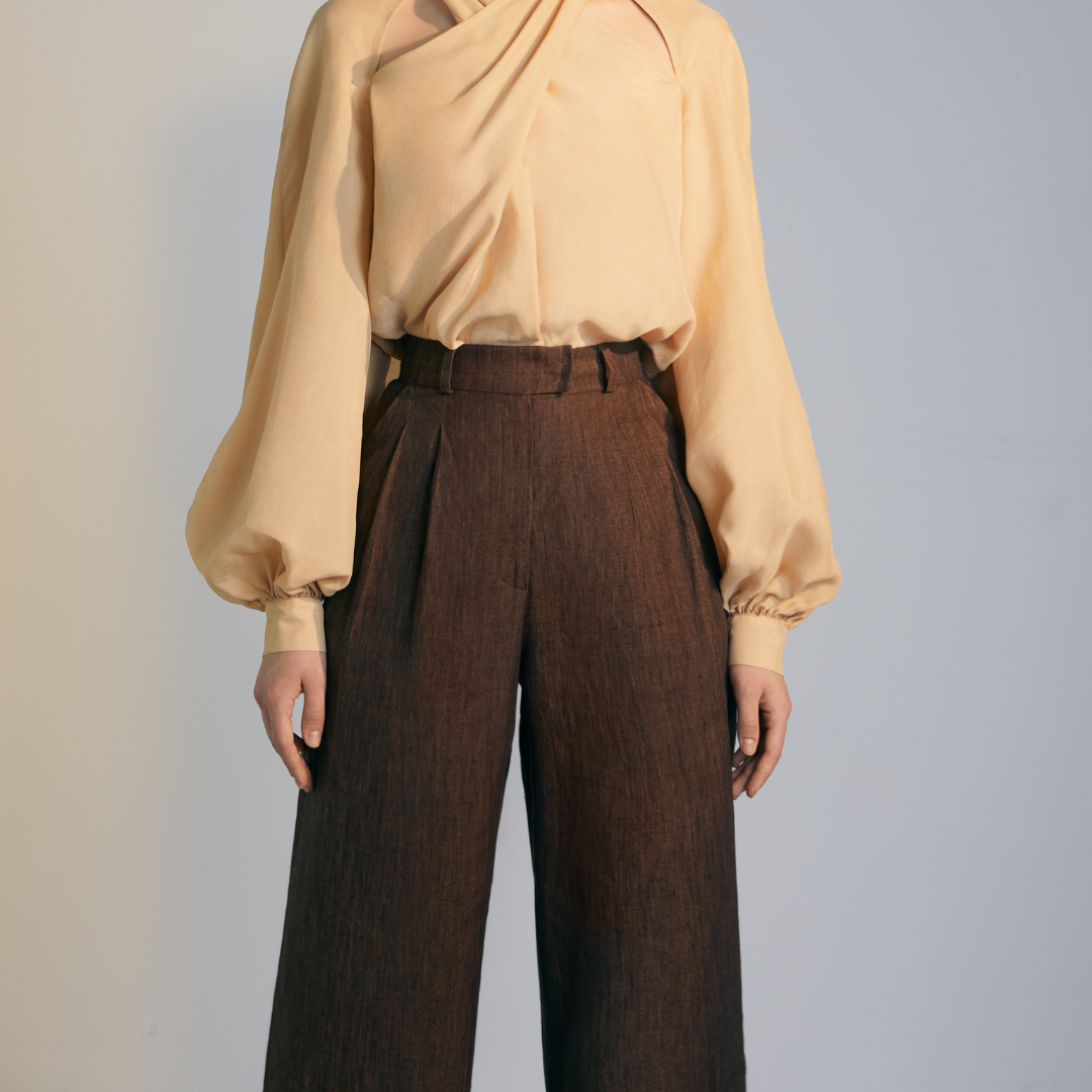 Close-up of the front of a model wearing brown colored loose Pants