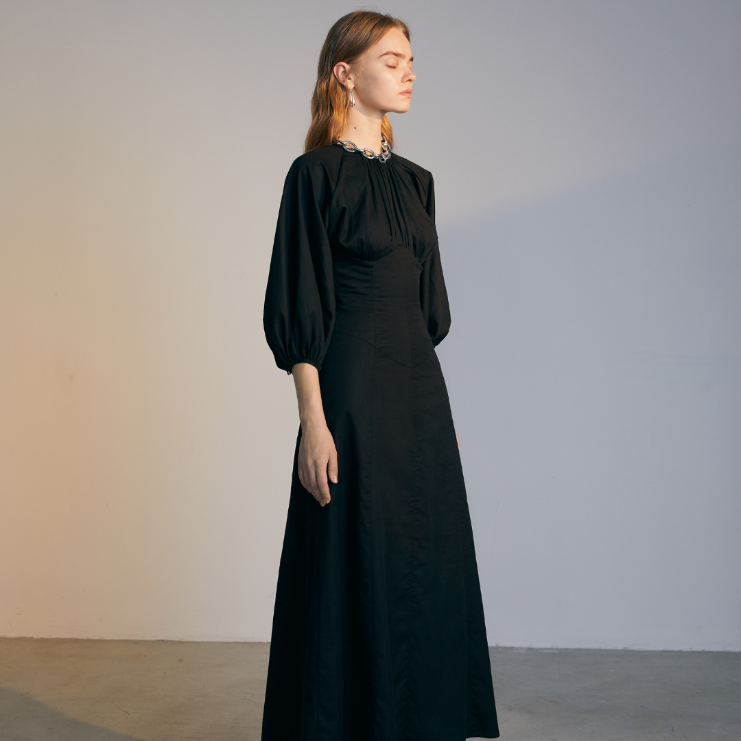 The side of a model wearing a black Gigot Sleeve Dress
