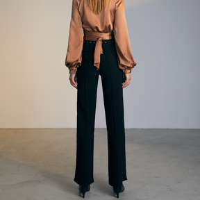 The back of a model wearing black high-waisted fitted pants
