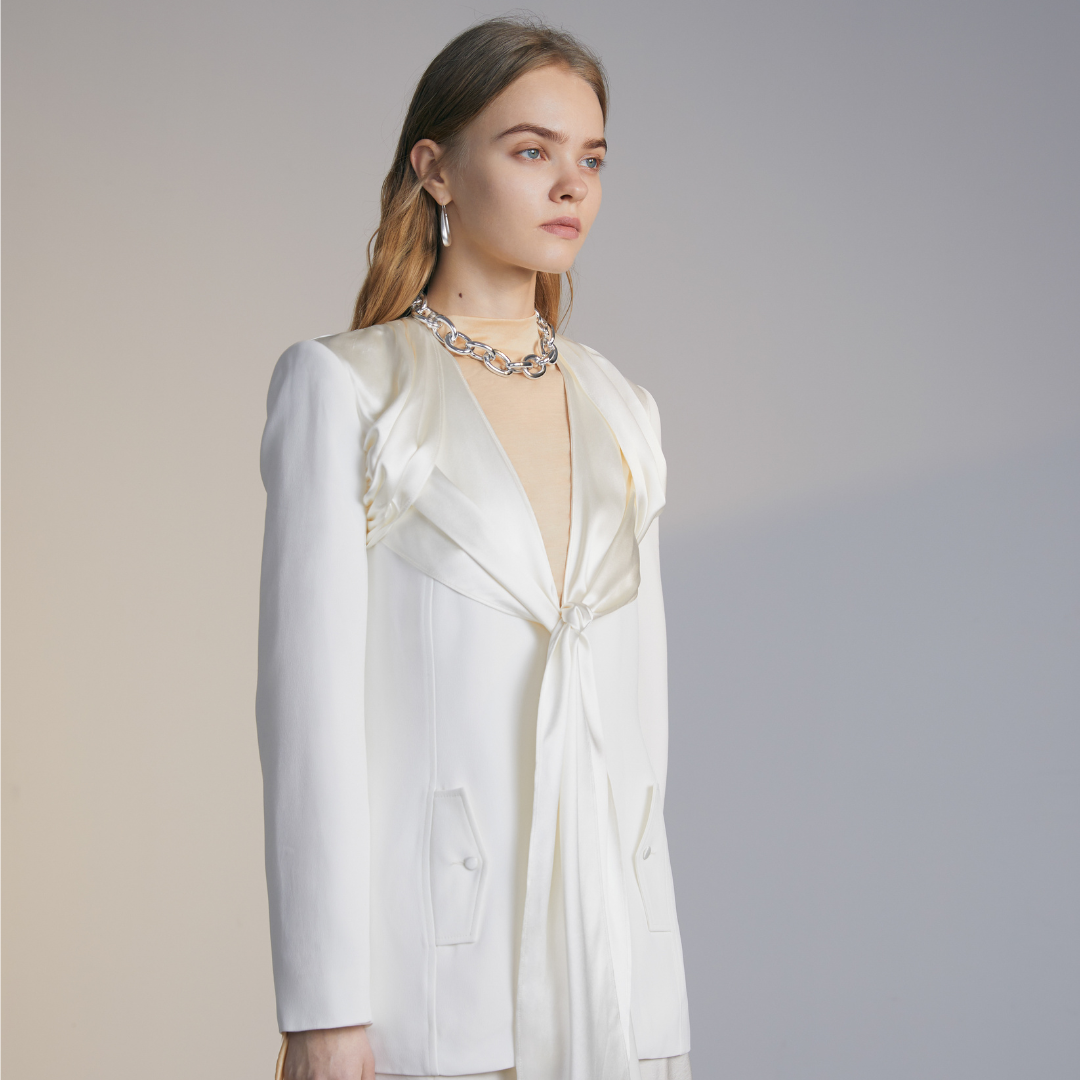 The side of a model wearing a white Knotted Suit Jacket