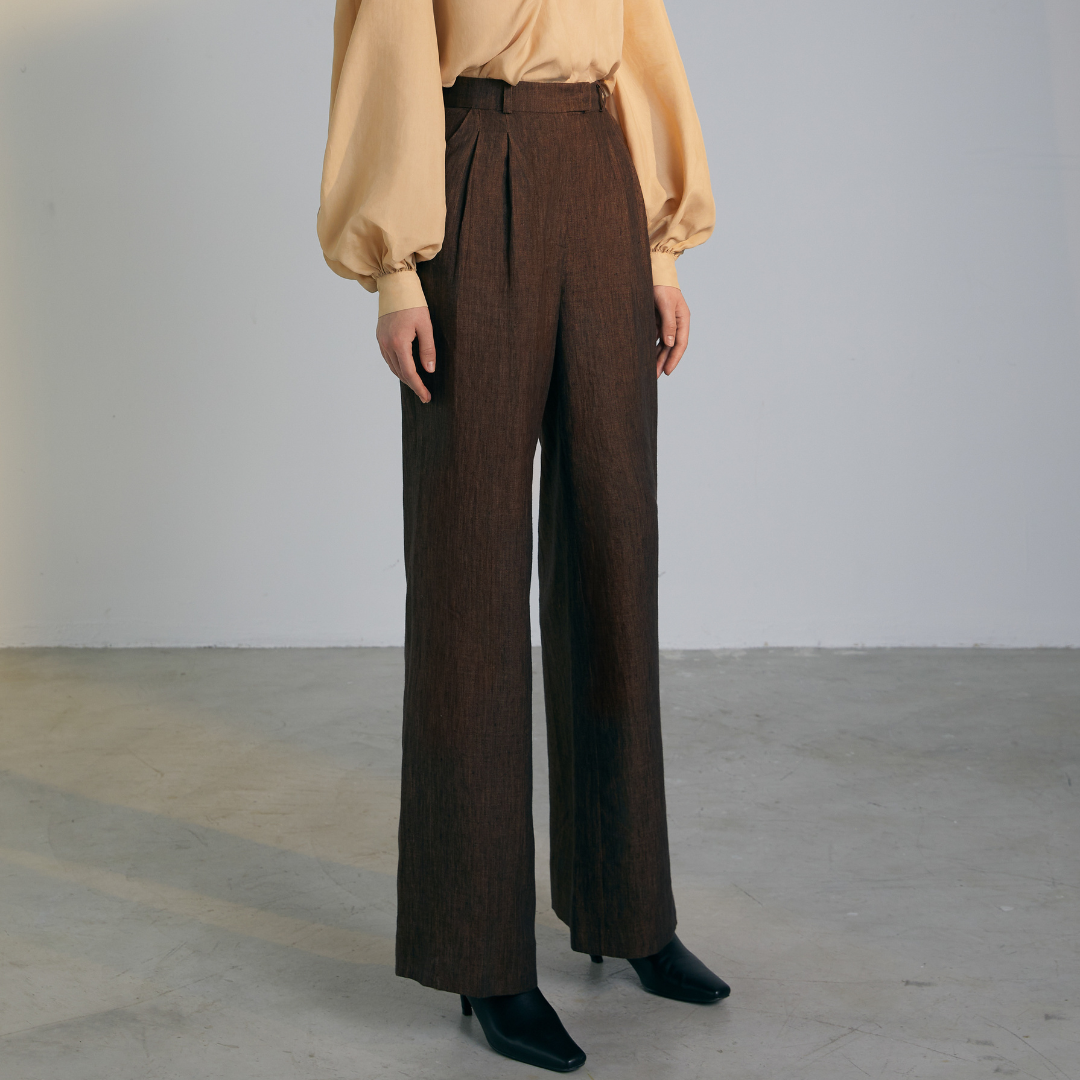 The front of a model wearing brown colored loose Pants