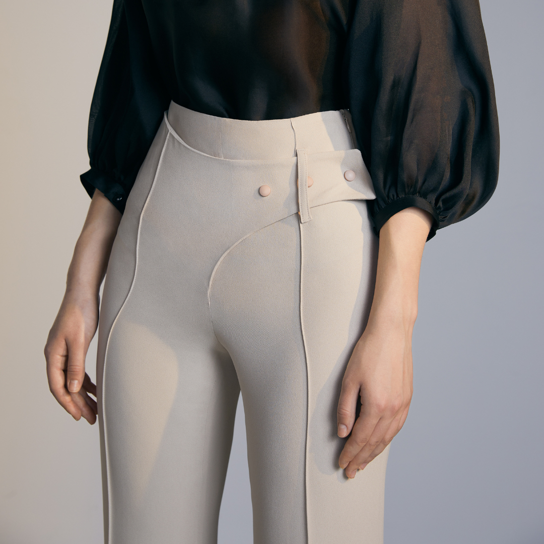 Close-up of A model wearing Natural colored Asymmetrical Belt Pants