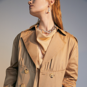Close-up of the front of a model wearing a beige colored Trench Coat