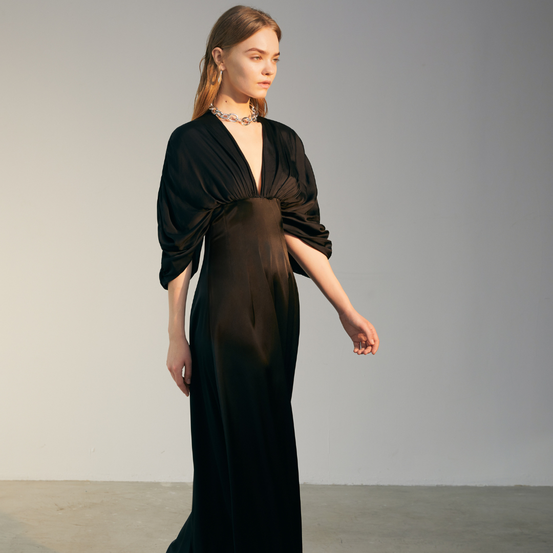 The side of a model wearing a black Bat Sleeve Dress