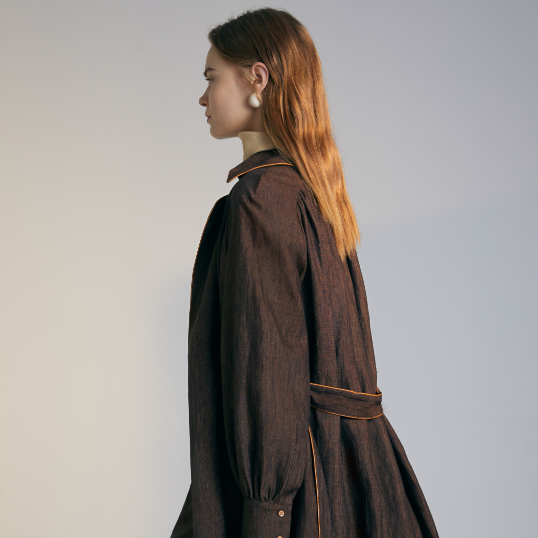 The side of a model wearing a brown colored Long Coat