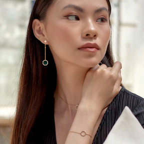 A model wearing MIMOSA EN MÉMOIRE rose gold Earrings 68 Diamonds Malachite