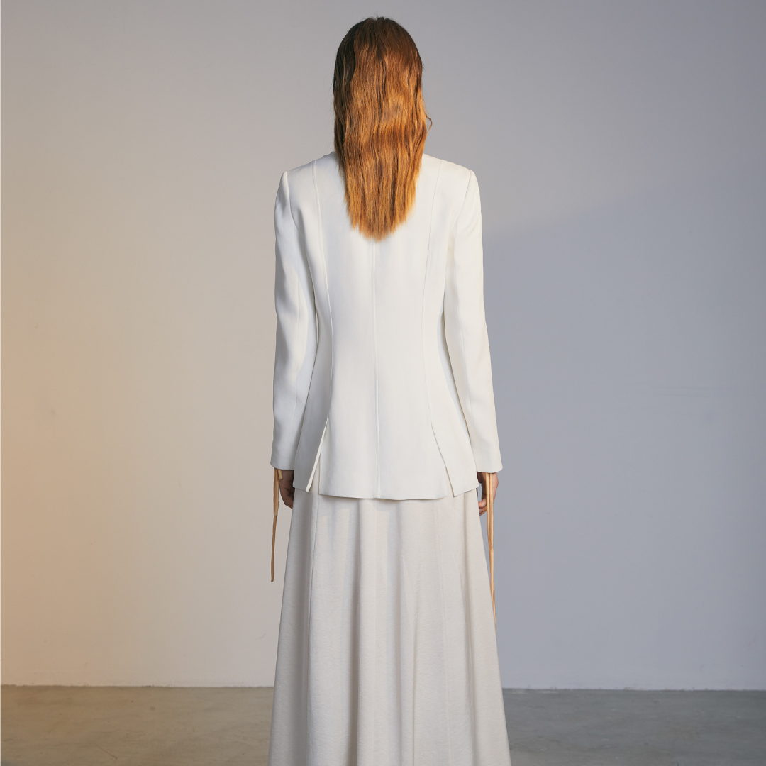 The back of a model wearing a white Knotted Suit Jacket